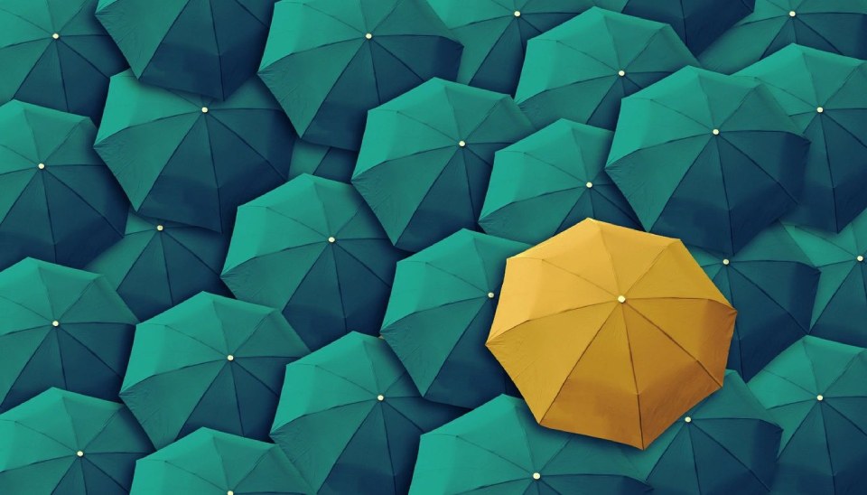 An Yellow Umbrella in a Group of Green Umbrellas